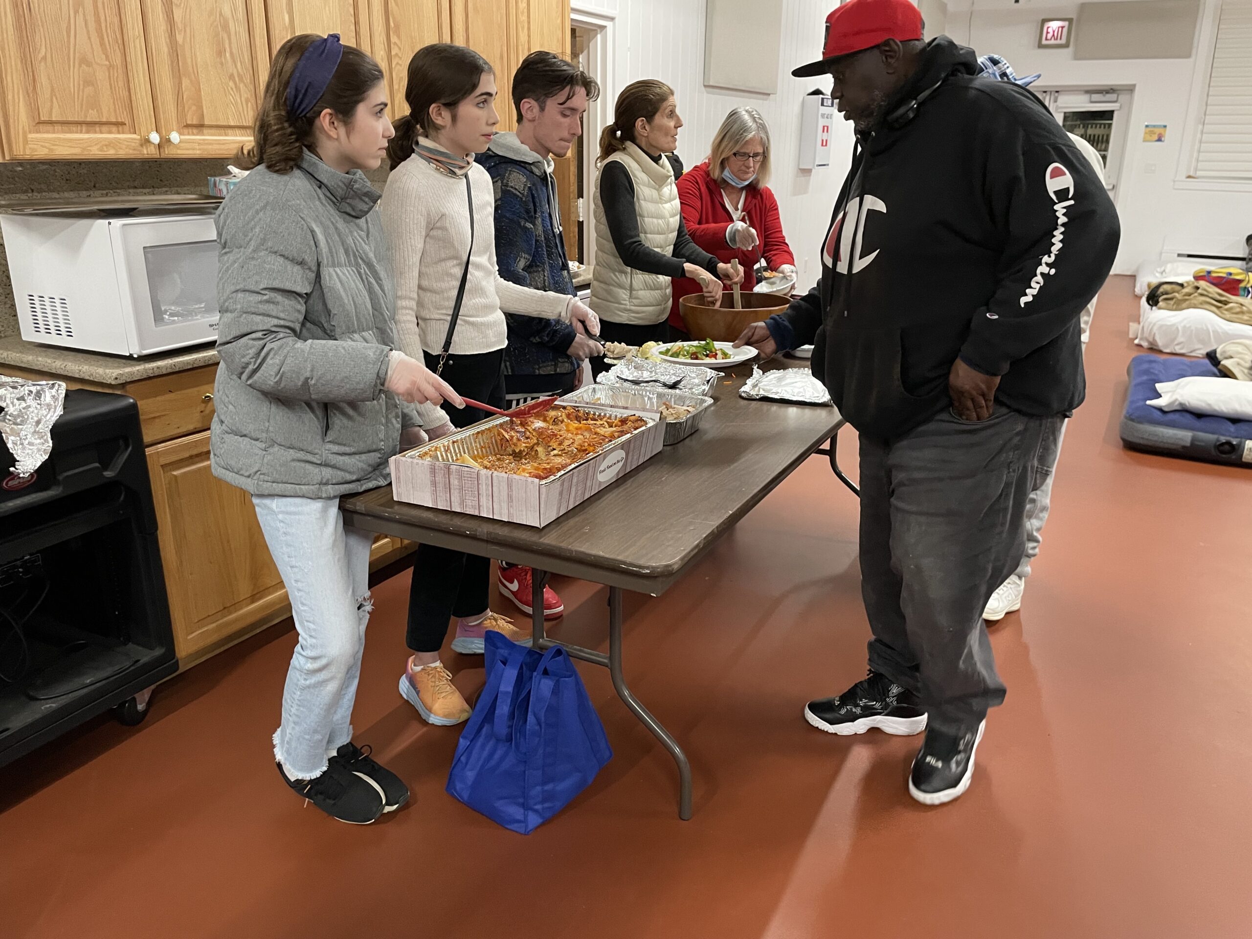 five st johns parishioners serving a meal to a man at maureens haven in southampton new york