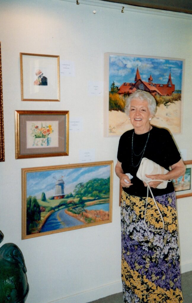 woman standing in front saint johns annual art show exhibit of paintings for purchase